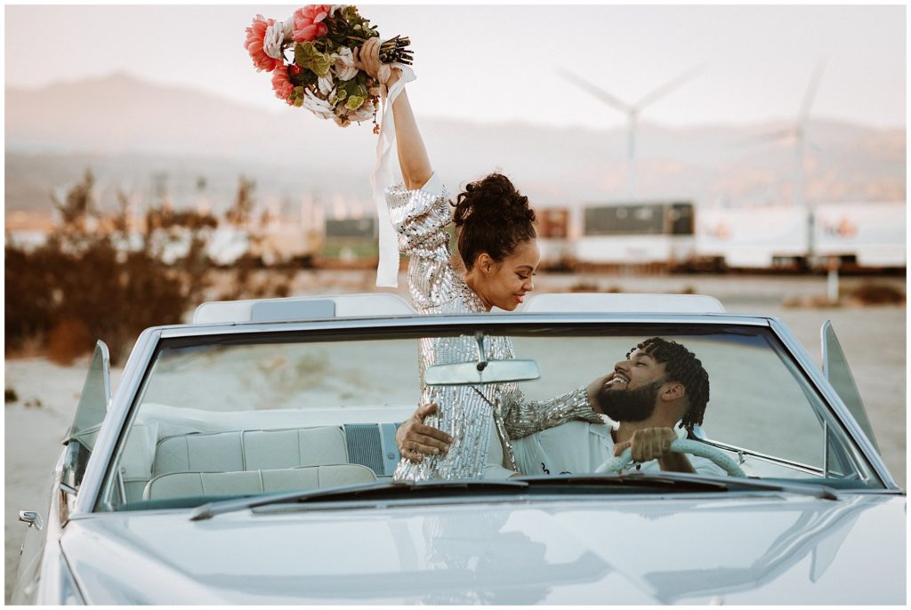 couple poses in a classic car in palm springs