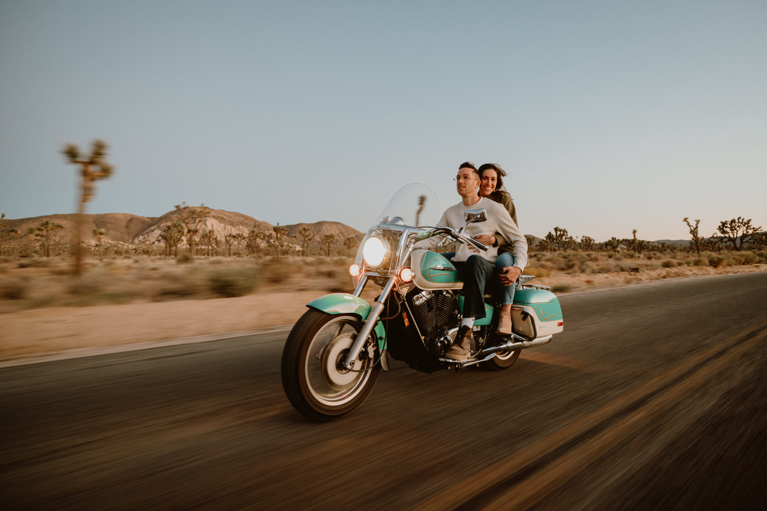 couple rides motorcycle in joshua tree for their engagement session